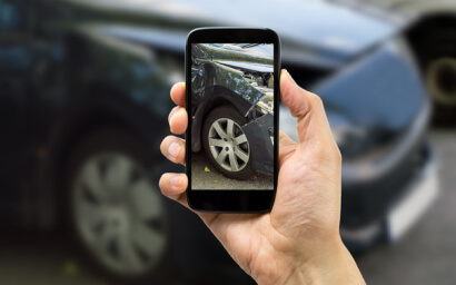 Man taking photo of his damaged car