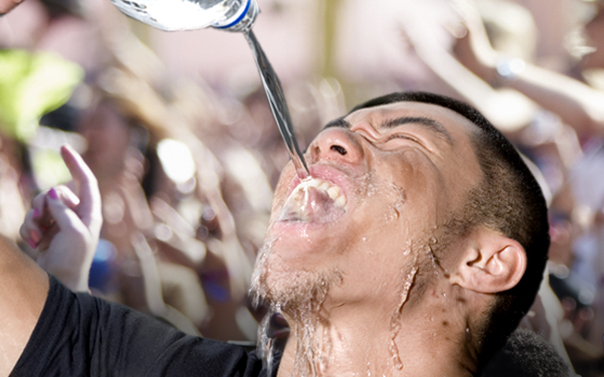 man pouring water in mouth