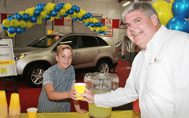 Mercury executive handing lemonade to a kid