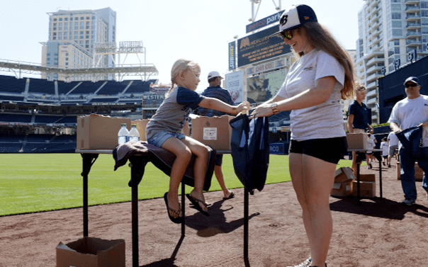 mother and son making care packages at petco park for U.S. troops