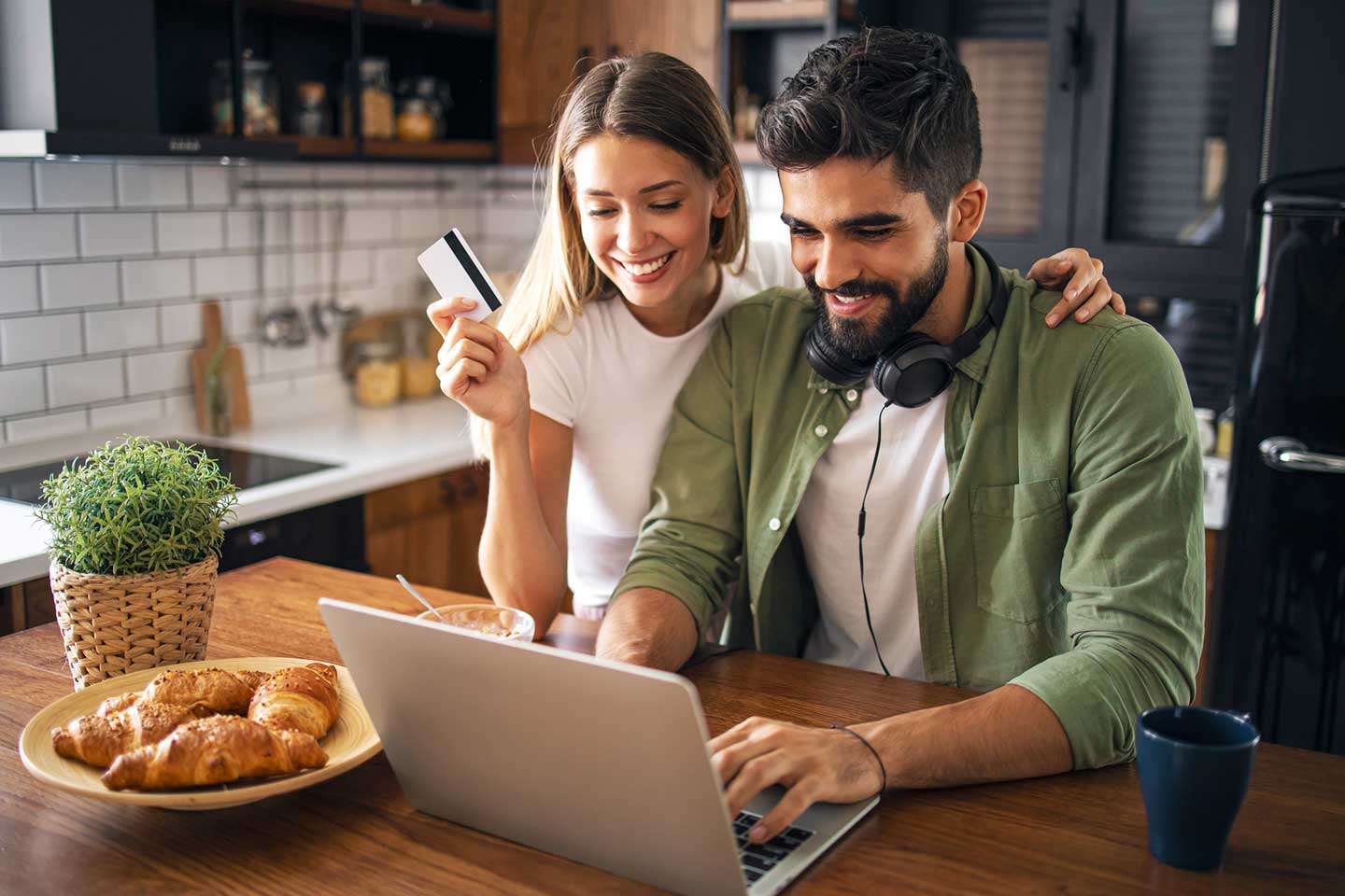 Happy couple shopping for insurance online from their kitchen