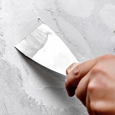 Man filling wall gaps and seams with putty