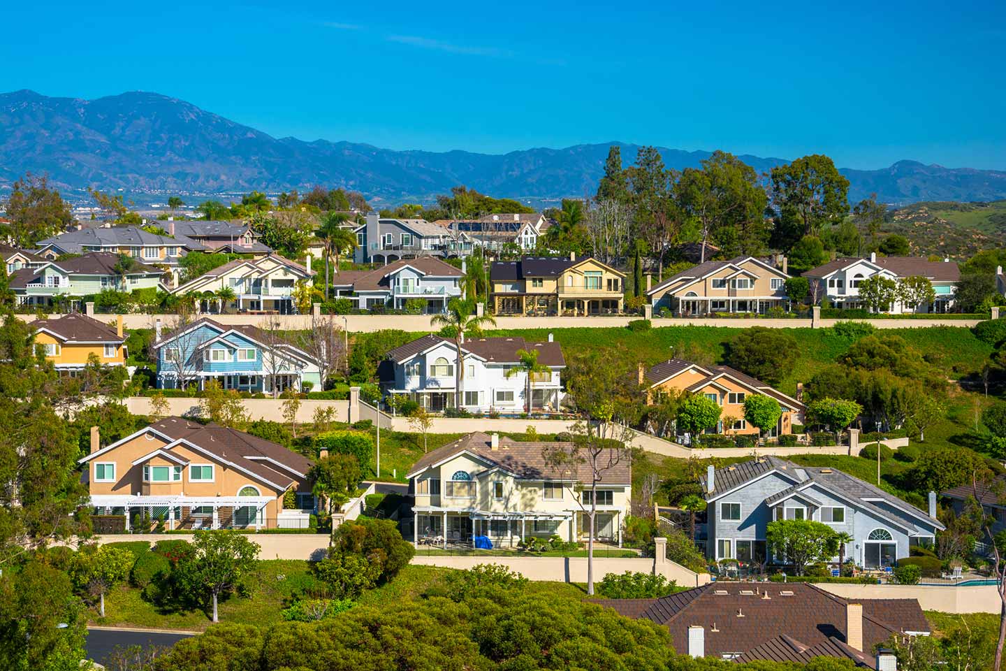 A hillside of CA houses with mountains in the background