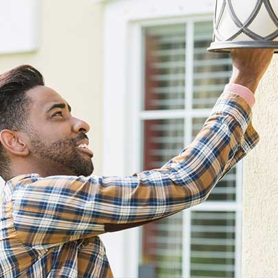 Homeowner changing outdoor lightbulb