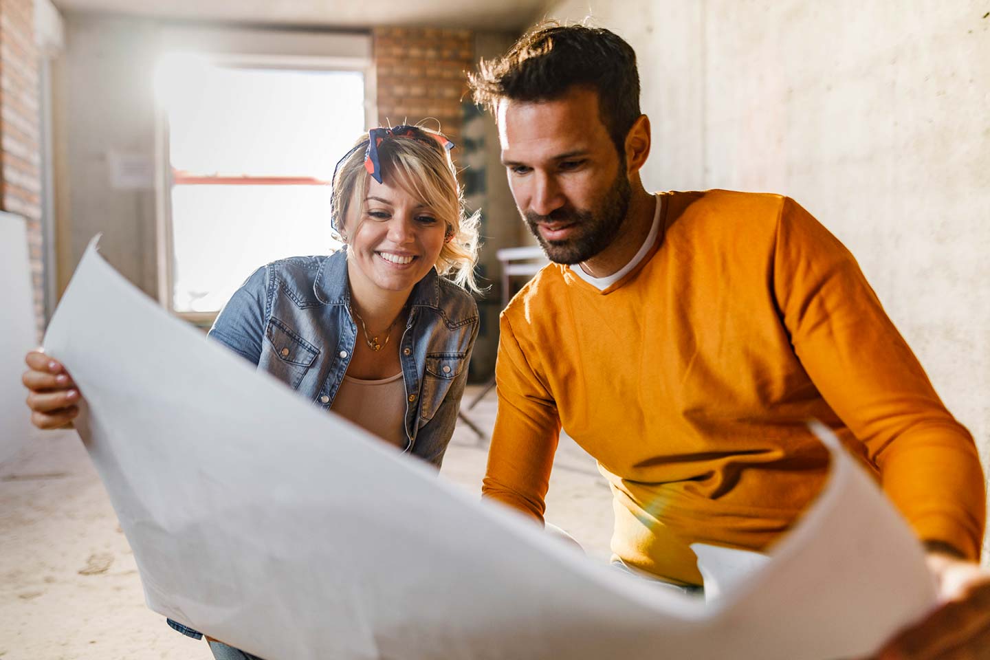 Young couple examining blueprints during home renovation process