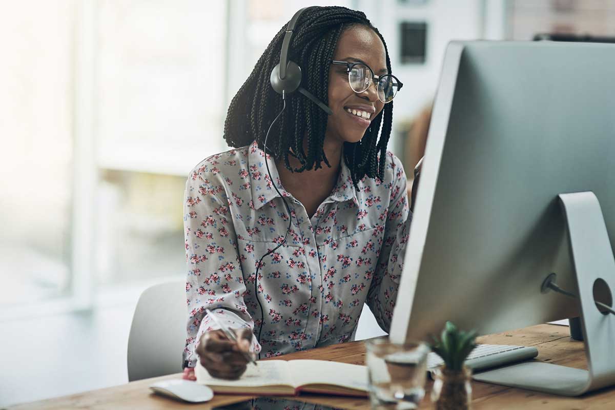 Auto claims representative at computer talking with customer on phone