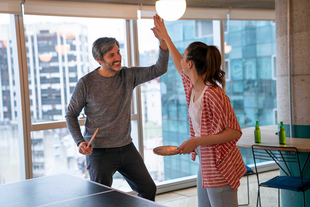 Colleagues celebrating their win playing ping pong at the office