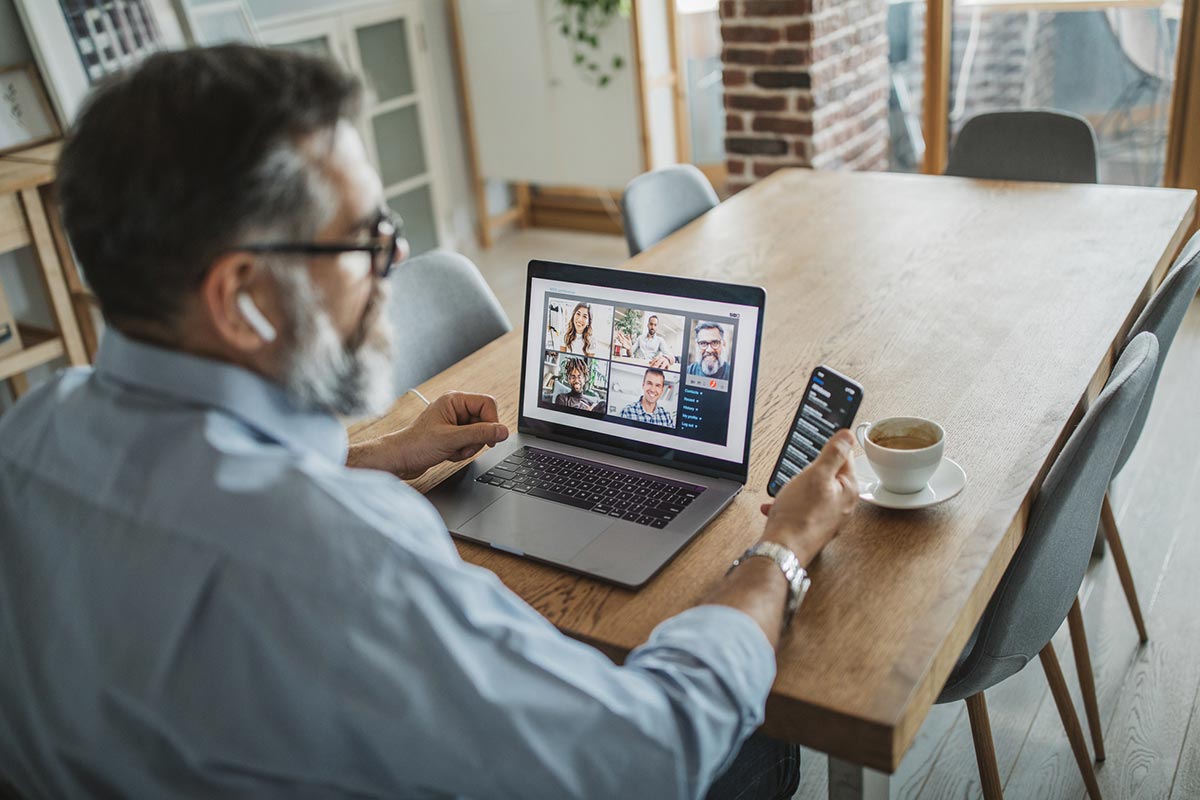 Man speaking with team over video conference on computer