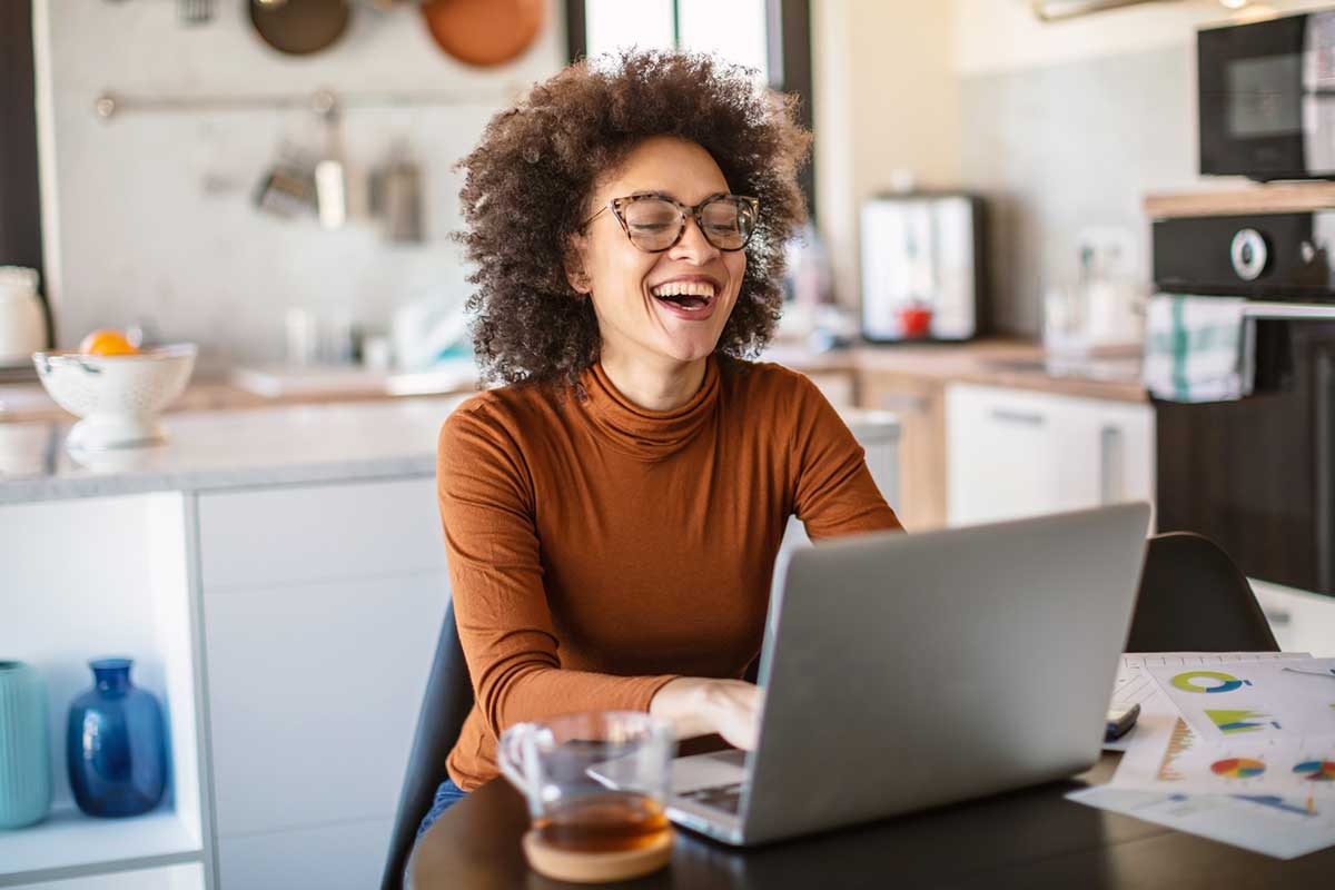 Woman working remotely from home in kitchen