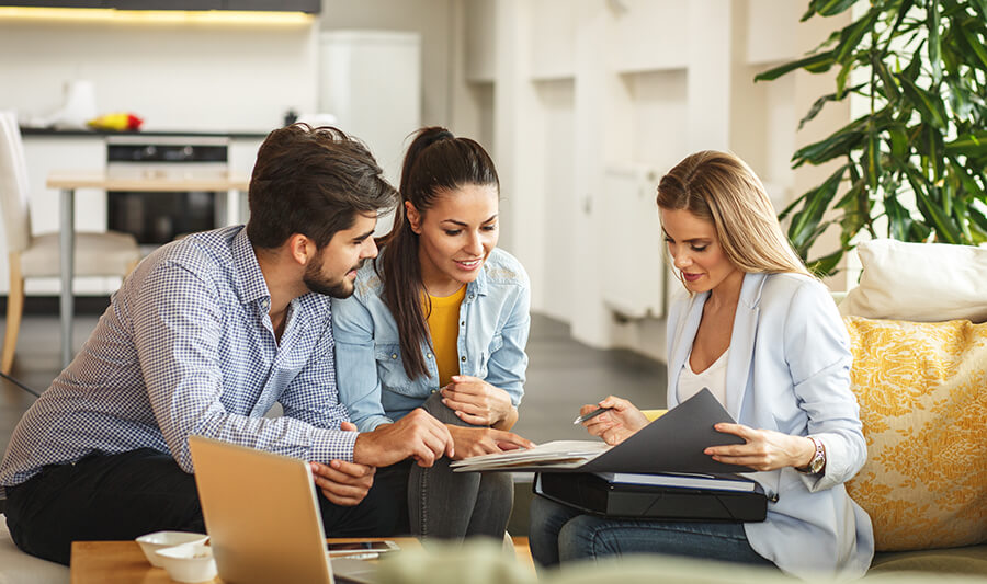 Couple talking with insurance agent at home.