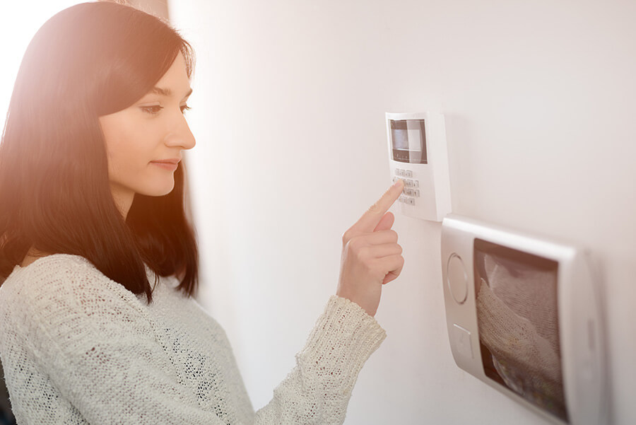 Woman typing in code to home security system