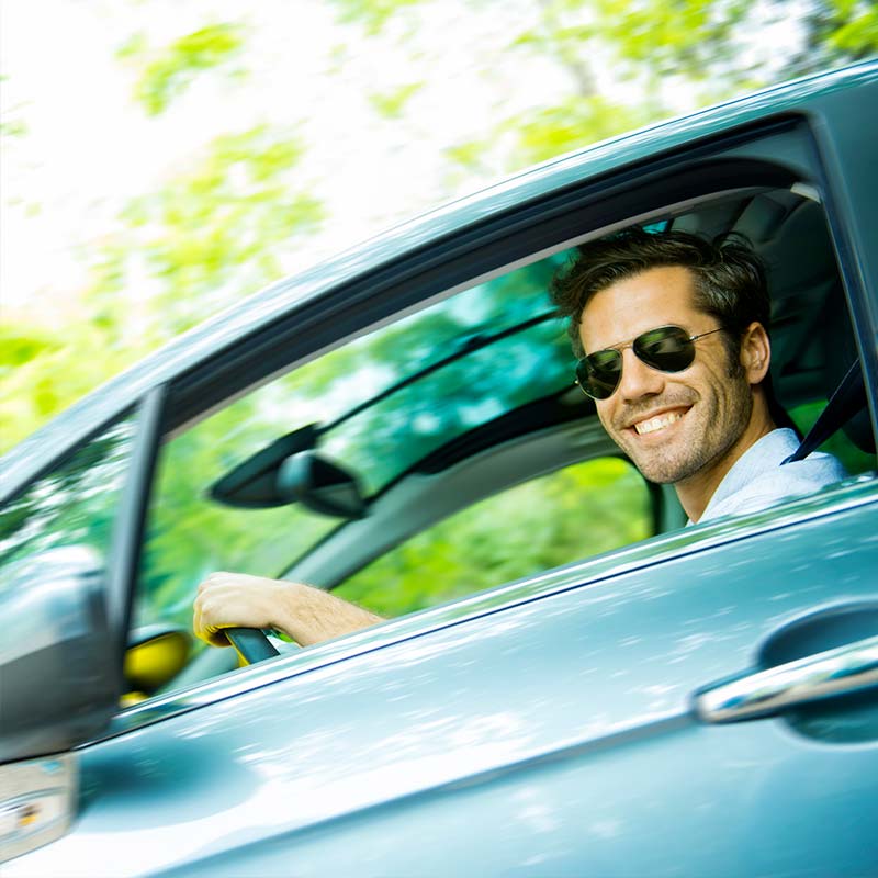 Middle age man with sunglasses driving a car