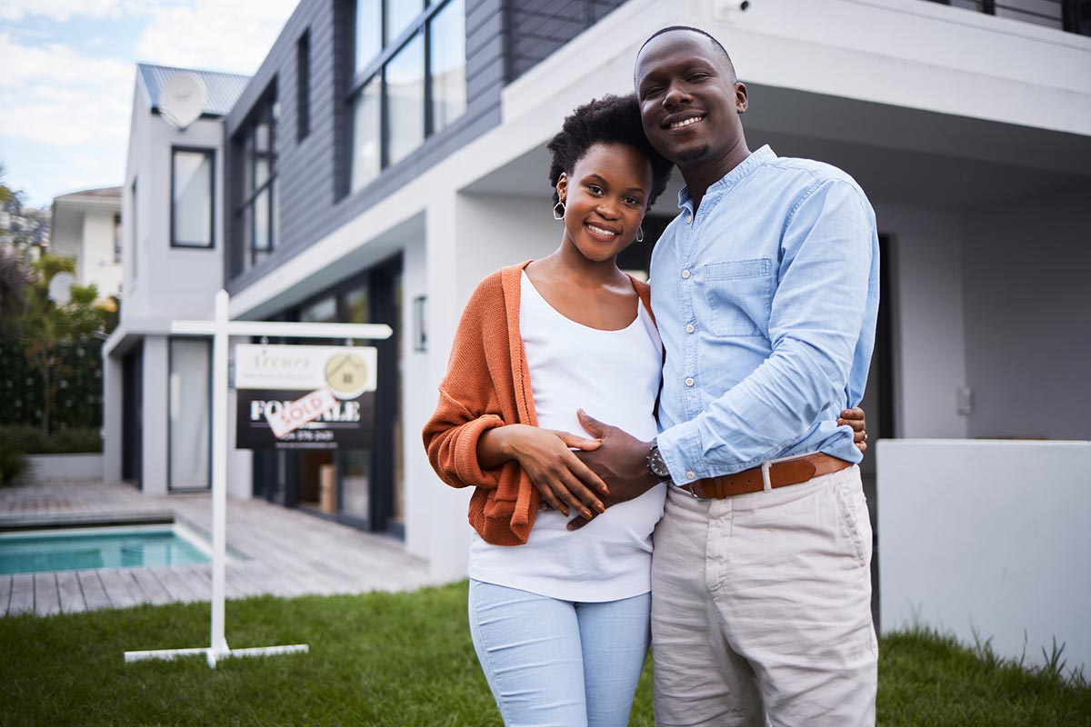 Portrait of a young couple standing outside their new home
