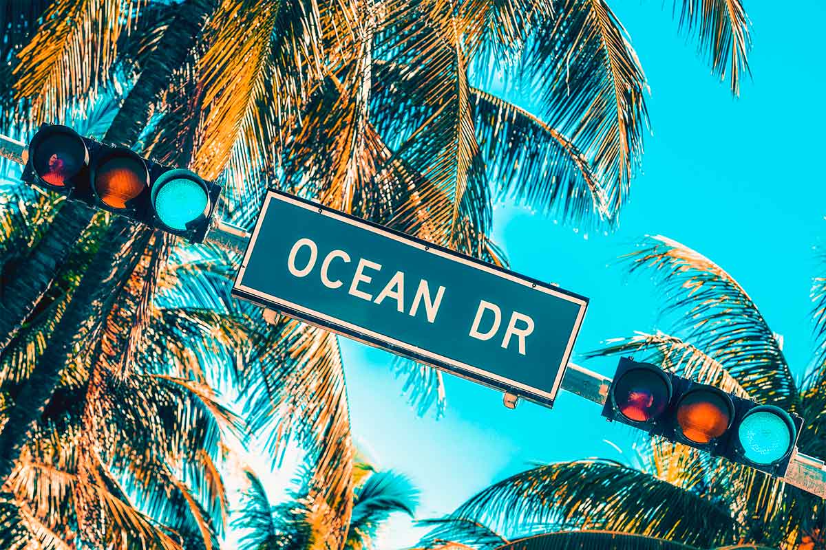 Street sign of Miami’s Ocean Drive with palm trees