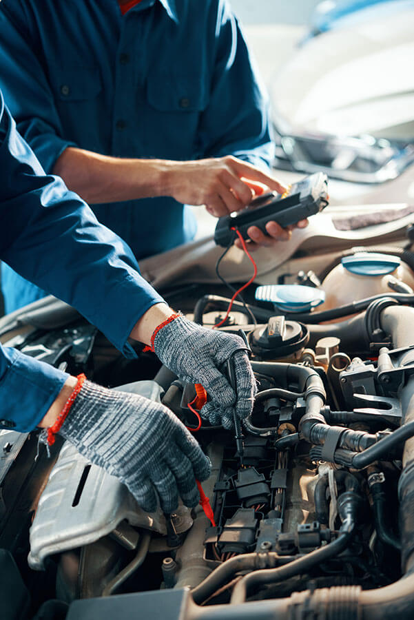 Two mechanics working on the engine of a car.